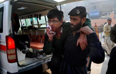 Полицейский выводит раненного заложника, Пакистан